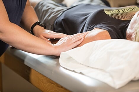 Therapist applying hands-on treatment to patient's arm