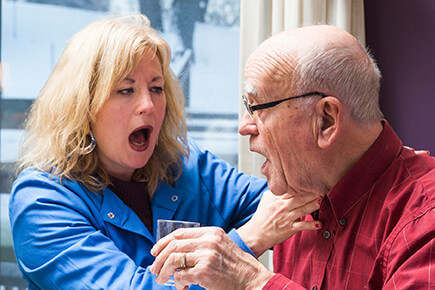 Speech therapist listens for a patient's dry voicing after swallowing.