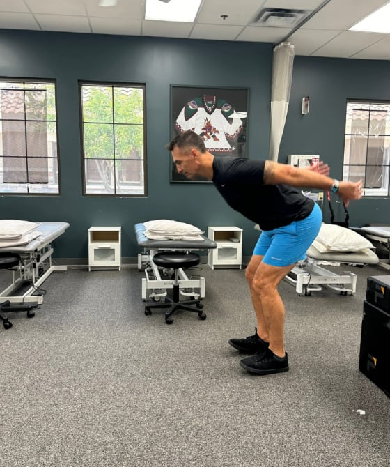 A male physical therapist preparing to jump forward. 