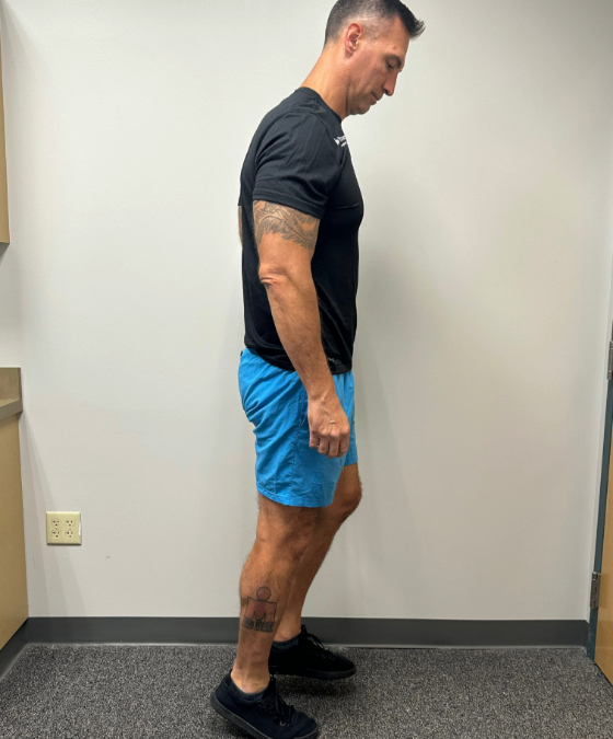 A male physical therapist on his tiptoes with his calves stretched.  