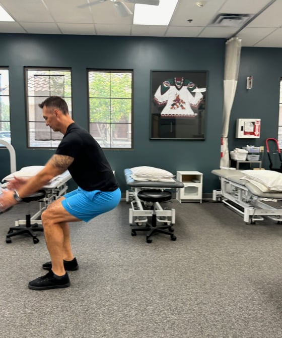 A male physical therapist landing from jumping forward. 