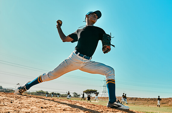 Closeup of a pitcher as he is throwing a baseball from the mound