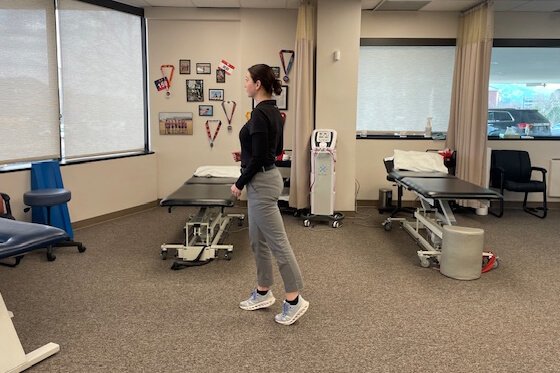 Therapist demonstrating walking toe raise stretches.