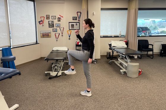 Therapist demonstrating high knees stretches.