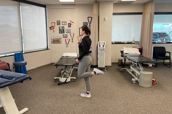 Therapist demonstrating 'butt kicker' stretches.