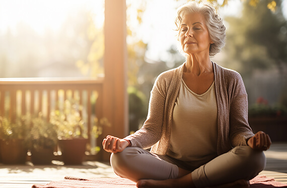 Woman sitting on the ground outside practicing meditation