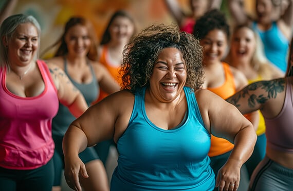 A group women smiling during a fitness dance class